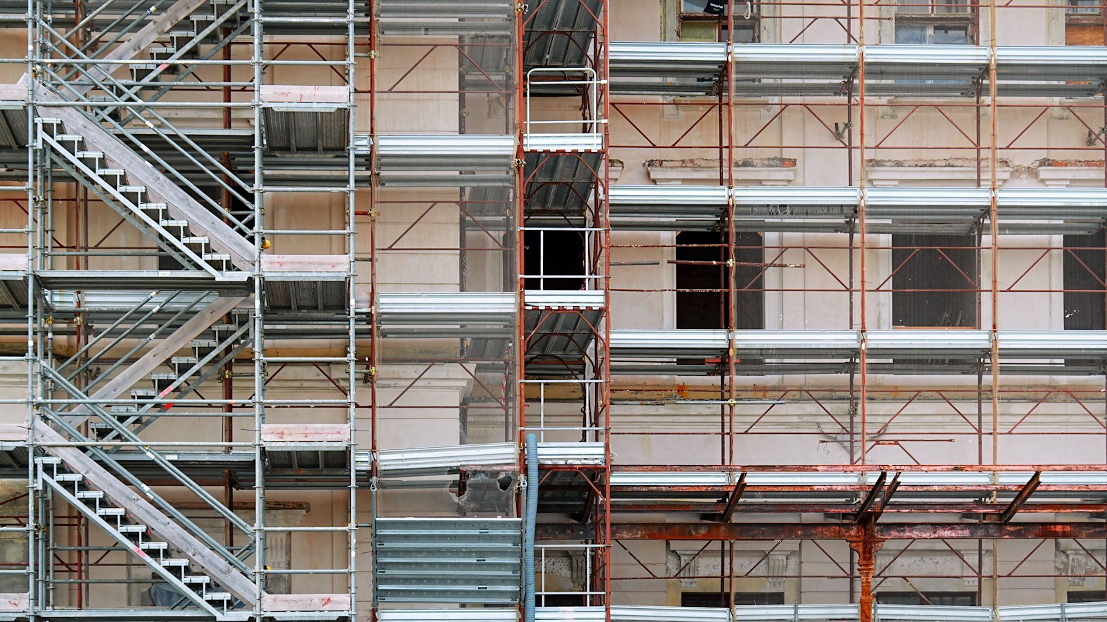 Building under construction wrapped in scaffolding, its structure rising floor by floor