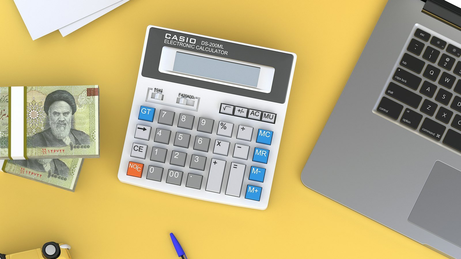A calculator beside a laptop on a desk, evoking cash forecasting and financial reporting