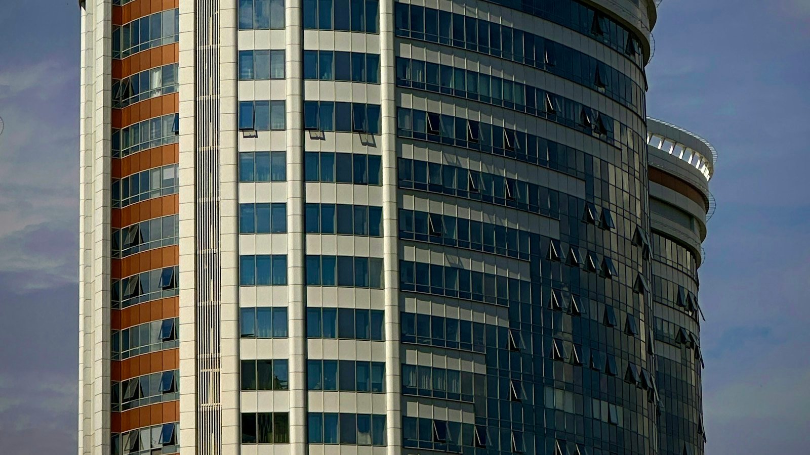 Modern glass skyscraper rising against a clear blue sky